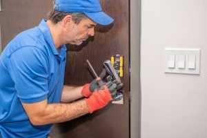 Home Professionele slotenmaker installeert een veilig slot aan een huisdeur voor optimale huisbeveiliging